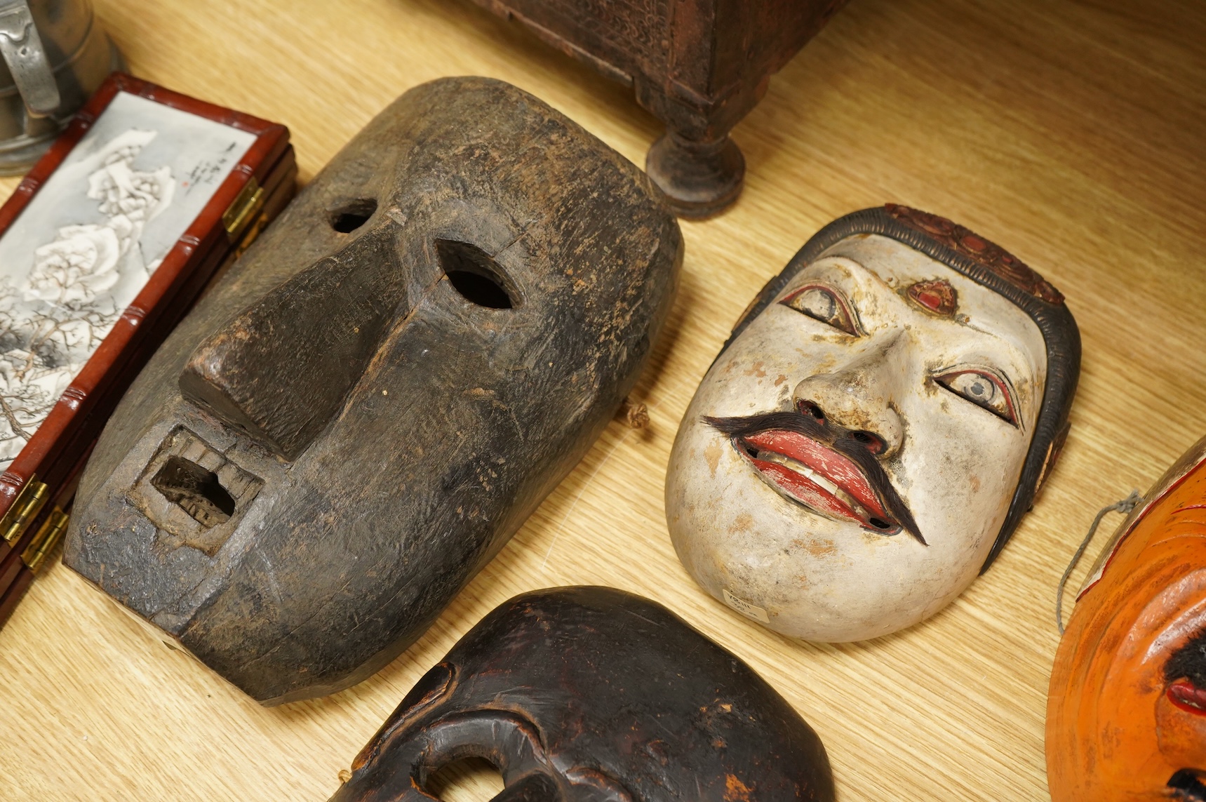 A collection of seven Nepalese, African and Indonesian masks to include a Magar example and one from the Dan Tribe, Liberia, largest 40cm